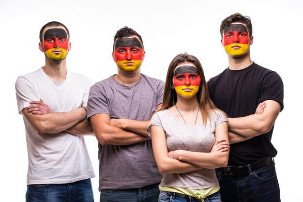 Groupe de personnes supporters fans des équipes nationales d'Allemagne avec le visage du drapeau peint isolé sur blanc. Émotions des fans.