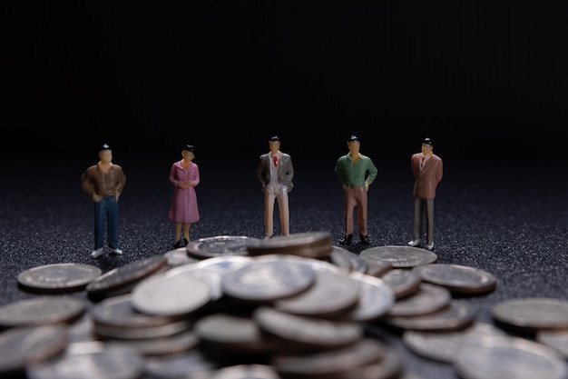 Photo gratuite groupe de petits entrepreneurs debout sur des pièces de monnaie