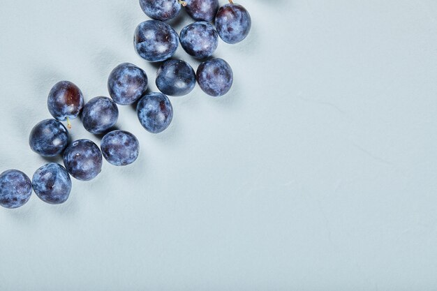 Groupe de prunes fraîches sur bleu.