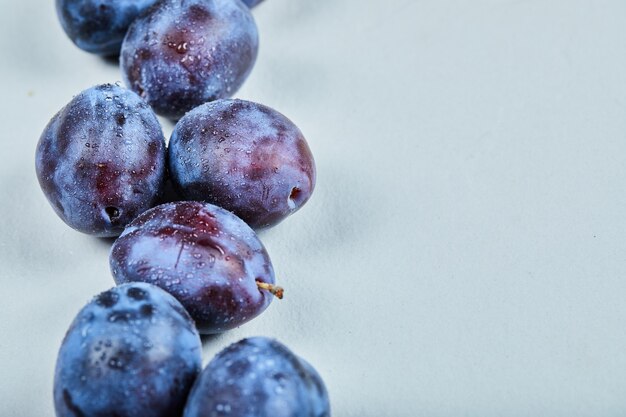 Groupe de prunes fraîches sur bleu.