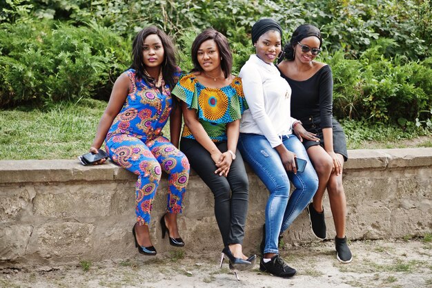 Groupe de quatre filles afro-américaines assis en plein air