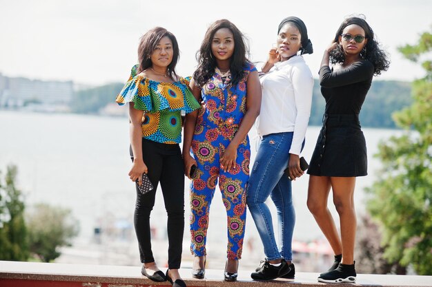 Groupe de quatre filles afro-américaines posées en plein air de bonne humeur