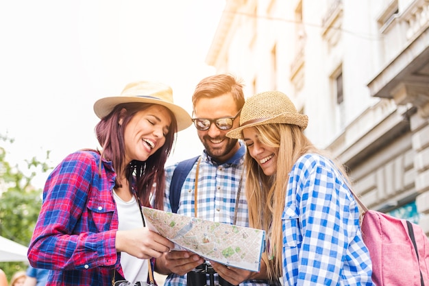 Photo gratuite groupe de randonneurs hommes et femmes heureux à la recherche d'un emplacement sur la carte