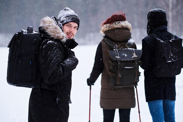 Groupe de routards en randonnée dans la forêt enneigée froide