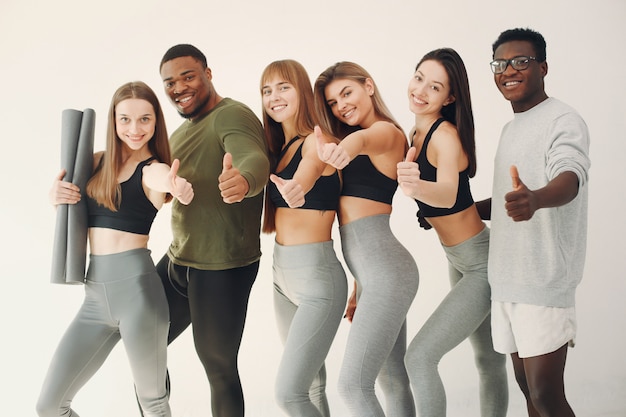 Groupe de sports debout sur un mur blanc