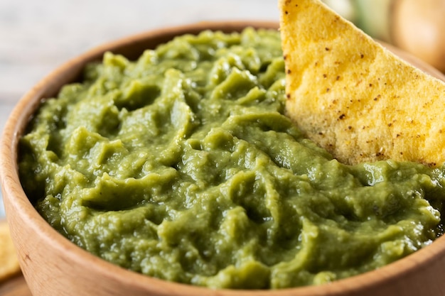 Guacamole mexicain avec puce nacho dans un bol en bois sur une table en bois rustique Vue de dessus Cuisine mexicaine traditionnelle