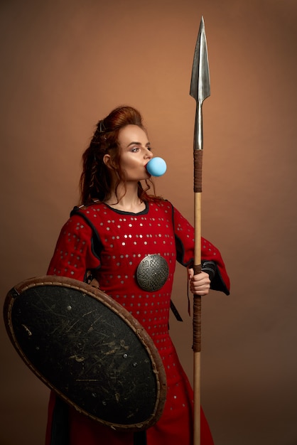 Photo gratuite guerrière soufflant de la grosse gomme à bulles bleues.