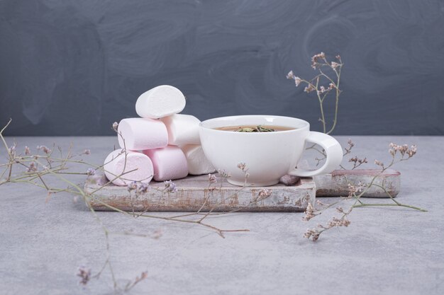Guimauves sur planche de bois avec tasse de thé. Photo de haute qualité
