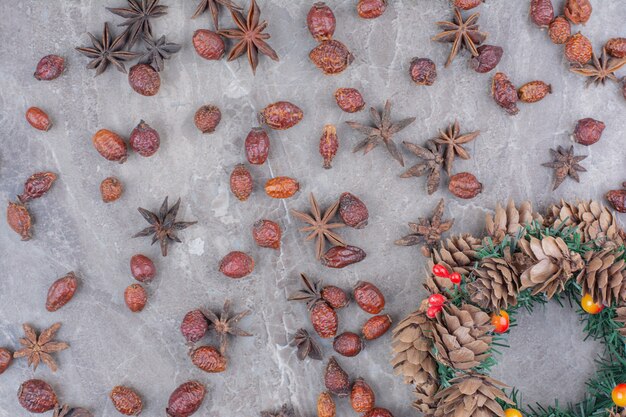 Guirlande de Noël avec pommes de pin et anis étoilé sur fond de marbre.