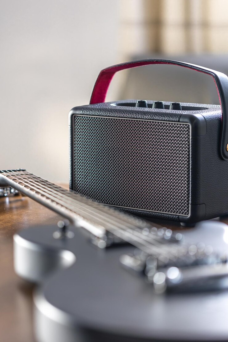 Photo gratuit guitare électrique noire et haut-parleur sur une table en bois