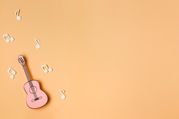 Guitare rose avec des notes de musique blanches