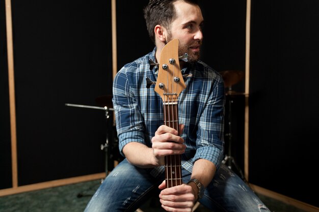 Guitariste sur chaise regardant vers la gauche