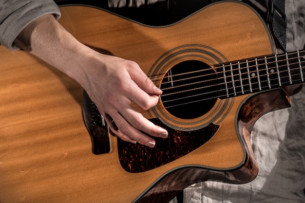 Guitariste, musique. jeune homme joue une guitare acoustique sur un noir isolé