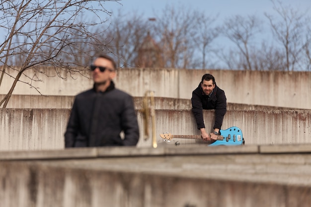 Photo gratuite guitariste suspendu au mur