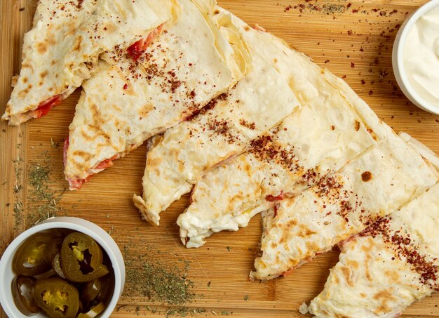 Gutab, qutab, gozleme de légumes de viande traditionnels sur une planche de bois avec du sumakh, du turshu et du yogourt.