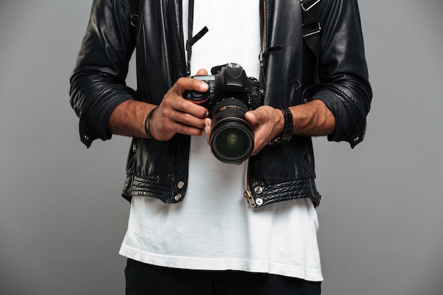 Guy afro américain élégant tenant un appareil photo numérique