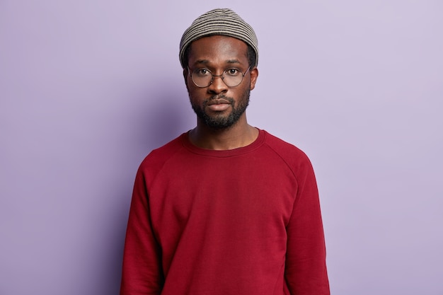 Guy afro-américain portant chemise rouge et chapeau à la mode