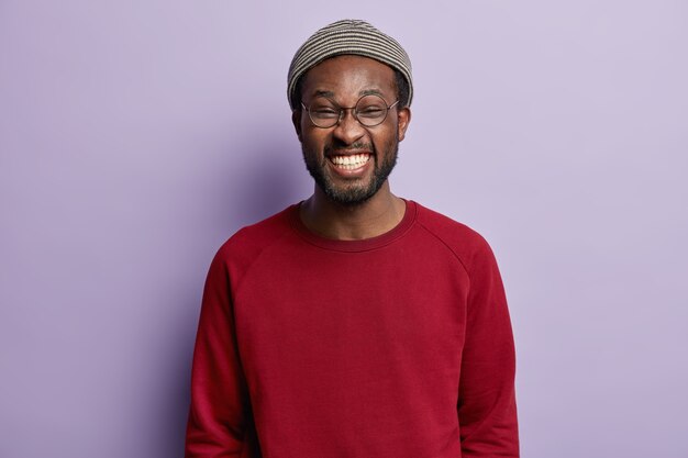 Guy afro-américain portant chemise rouge et chapeau à la mode