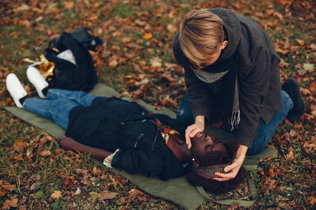 Photo gratuite guy aide une femme. afro girl est inconsciente. fournir les premiers soins dans le parc