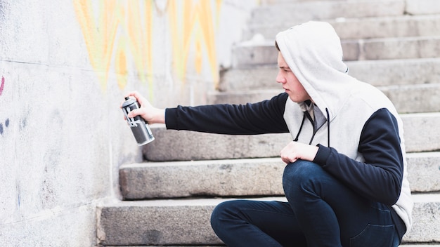 Guy dessin avec un spray sur le mur