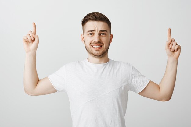 Guy grimaçant anxieux pointant les doigts avec le visage effrayé