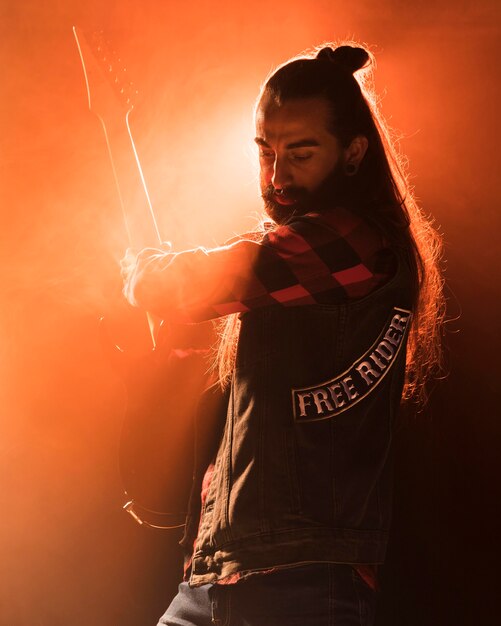 Guy de guitare cheveux longs jouant dans un groupe