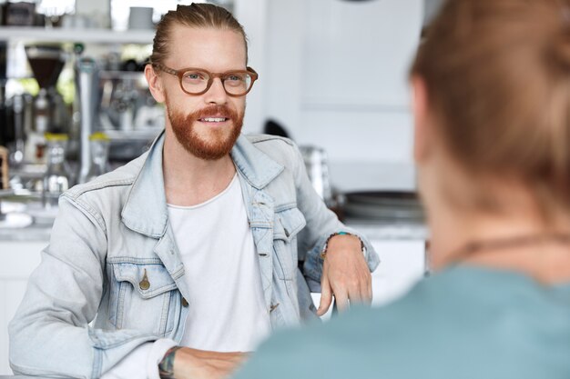 Guy de hipster à la mode assis avec une femme au café