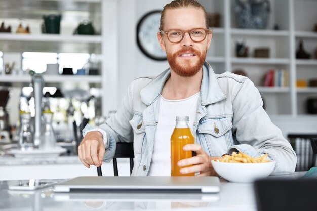 Guy hipster à la mode vêtu d'une chemise en jean et portant des lunettes élégantes