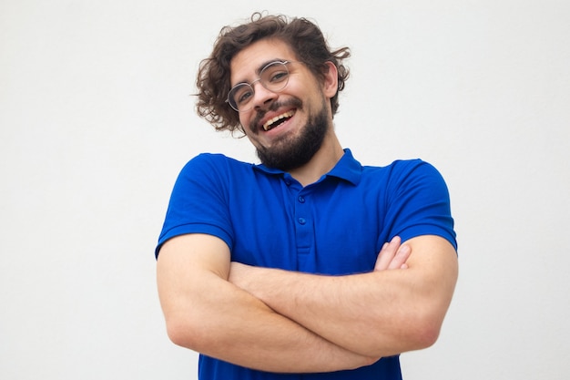 Guy insouciant positif avec les bras croisés en haussant les épaules