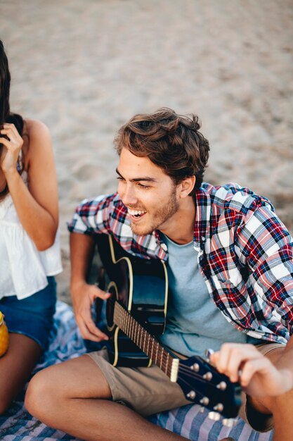 Guy jouant de la guitare à la plage