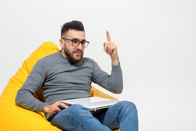 Guy a pris une idée alors qu'il était assis sur une chaise pouf jaune