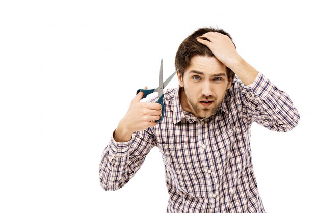 Guy regarde le miroir tout en se coupant les cheveux, coupe de cheveux