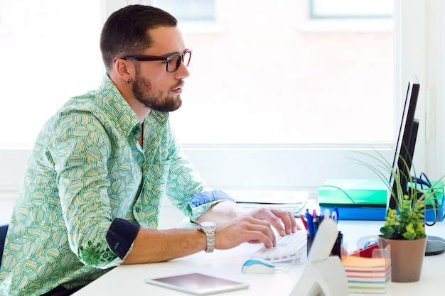 Guy travaillant sur ordinateur dans le bureau