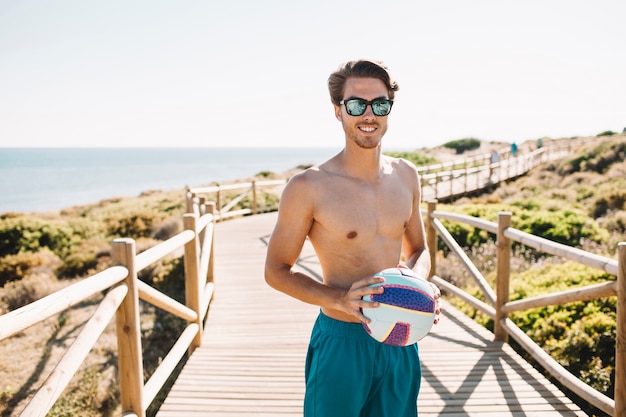 Guy avec volleyball à la plage