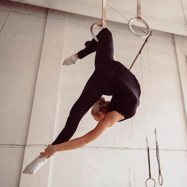 Gymnaste blonde faisant un exercice compliqué
