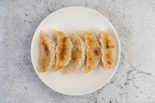 Gyoza dans un plat blanc.