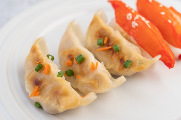 Gyoza dans un plat blanc.