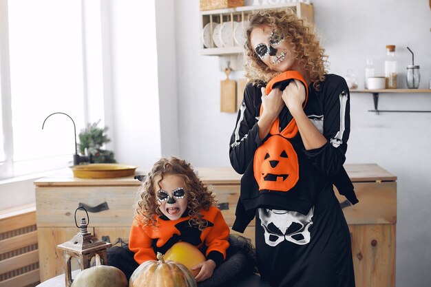 Halloween. Mère et fille en costume d'halloween de style mexicain. Famille à la maison avec des citrouilles.