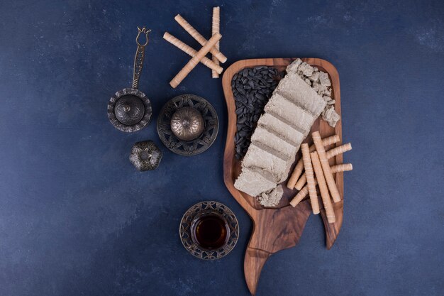 Halva tranché et servi avec des bâtonnets de gaufres et un verre de thé