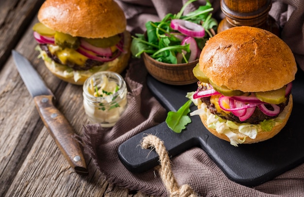 Hamburgers à angle élevé avec des cornichons sur une planche à découper