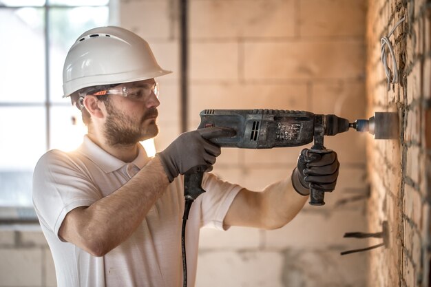 Handyman utilise un marteau-piqueur pour l'installation