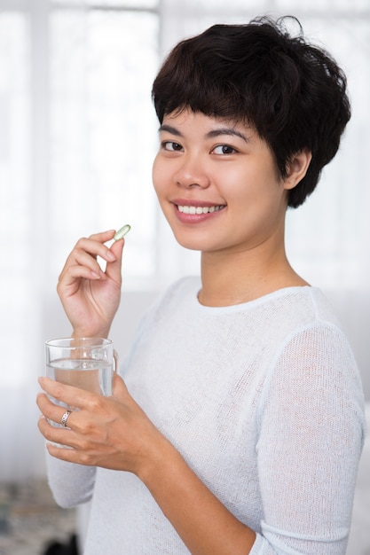 Happy Beautiful Asian Woman Taking Pill