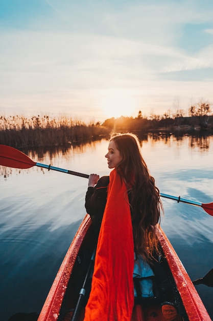 Happy cute woman holding paddle dans un kayak sur la rivière