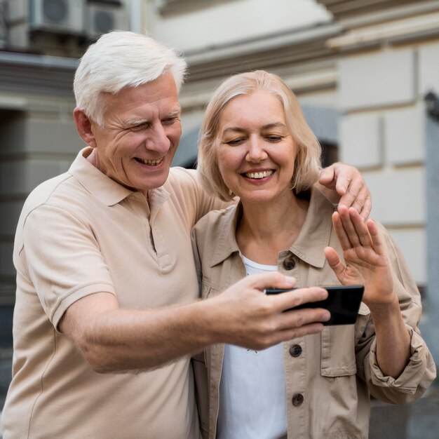 Happy senior couple ayant un appel de vue pendant que vous êtes dans la ville