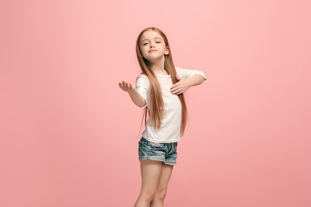 Photo gratuite happy teen girl debout, souriant isolé sur un studio rose à la mode