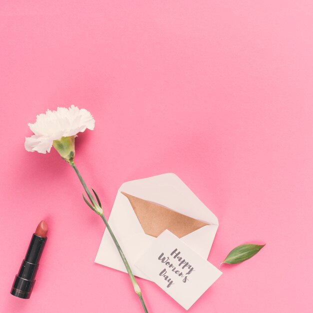Happy Womens Day inscription avec enveloppe et fleur sur table rose