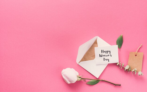 Happy Womens Day inscription avec enveloppe et fleur sur la table