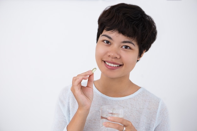 Happy Young Pretty Asian Woman Taking Pill