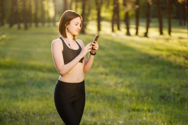 Happy young sportsgirl rend selfie portrait sur smartphone.