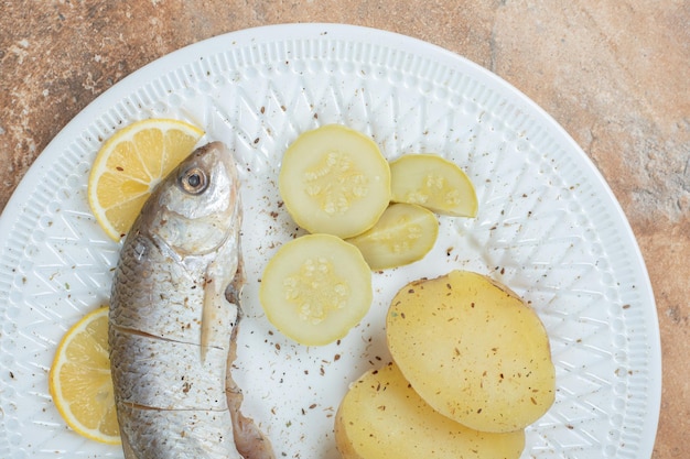 Photo gratuite hareng avec pommes de terre bouillies sur plaque blanche